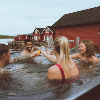 group of friends relaxing in jacuzzi with view of Lyngen Alps, Norway