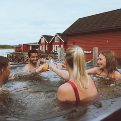 group of friends relaxing in jacuzzi with view of Lyngen Alps, Norway