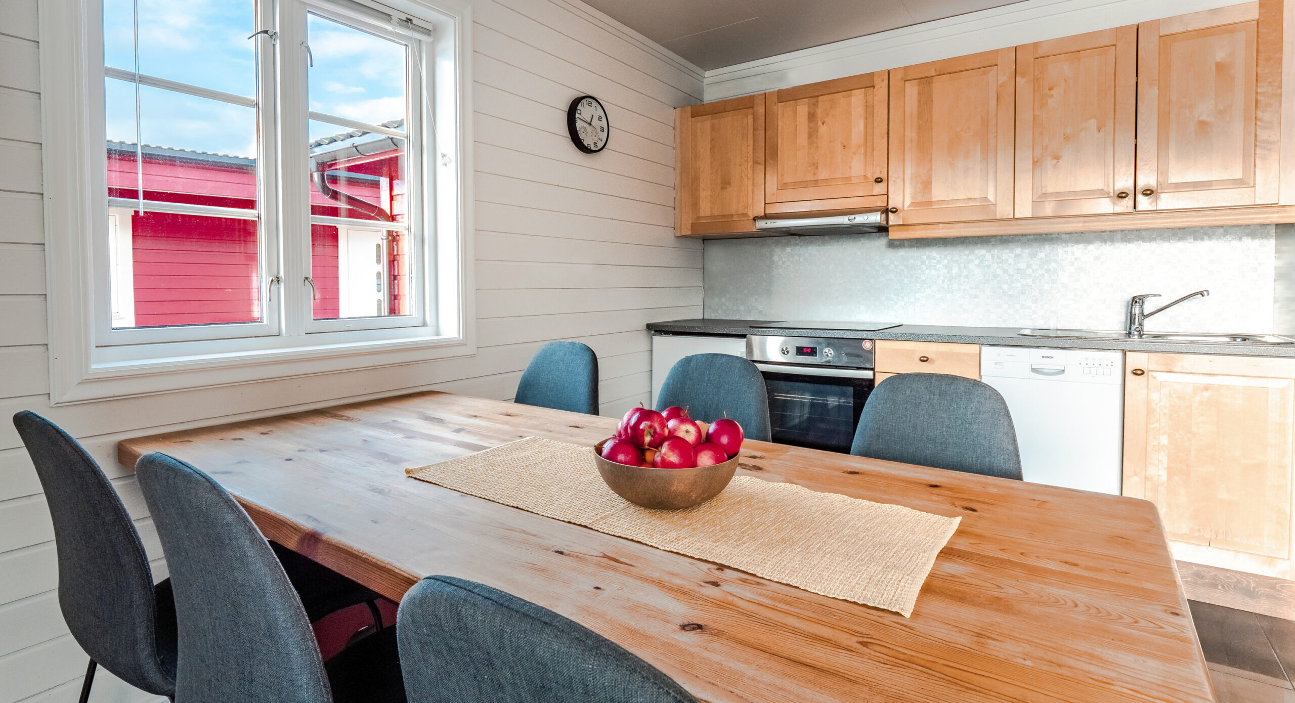 Interior of a waterfront cabin with floor-to-ceiling windows facing the Lyngenfjord