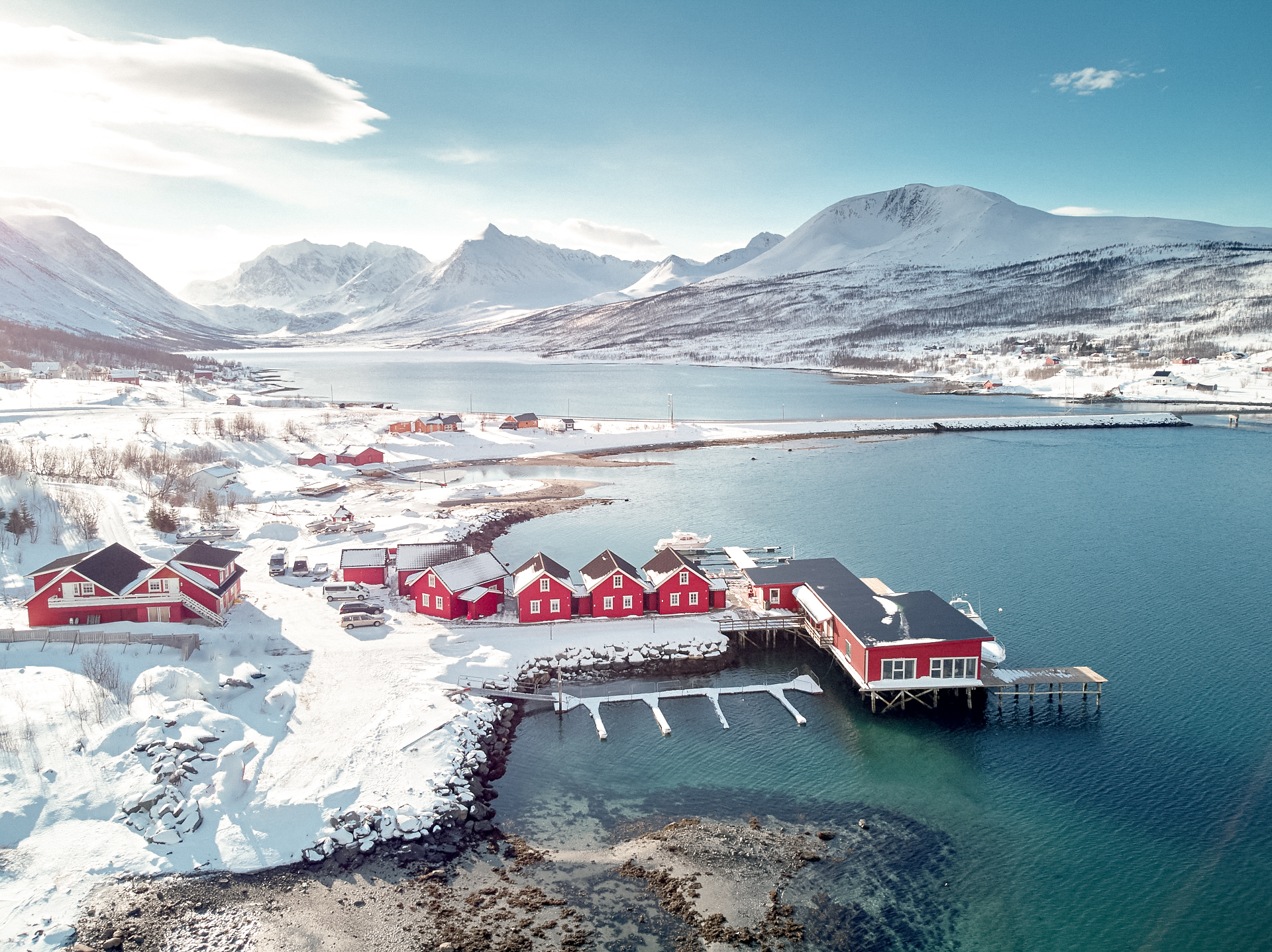XLyngen Arctic resort on the Lyngenfjord in the Lyngen Alps, Norway, with red cabins and mountain landscape